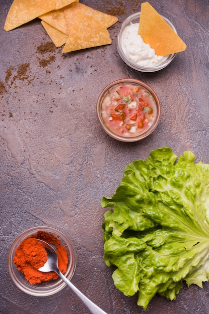 Verduras entre nachos con salsas y chile.