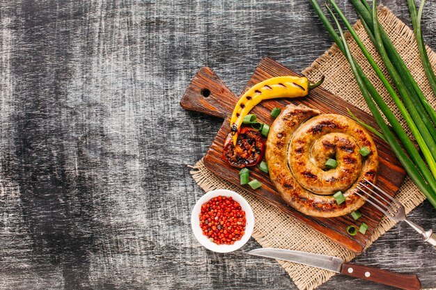 Verduras a la plancha y salchicha espiral con pimienta roja en grano.