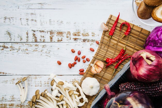 Verduras saludables; especias Champiñones y cacahuetes en mantel sobre mesa de madera