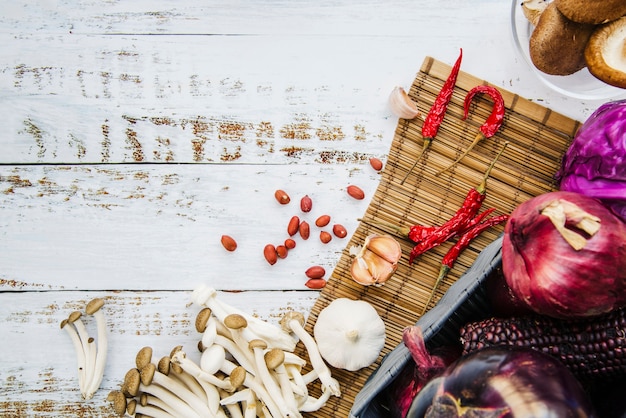 Verduras saludables; especias Champiñones y cacahuetes en mantel sobre mesa de madera