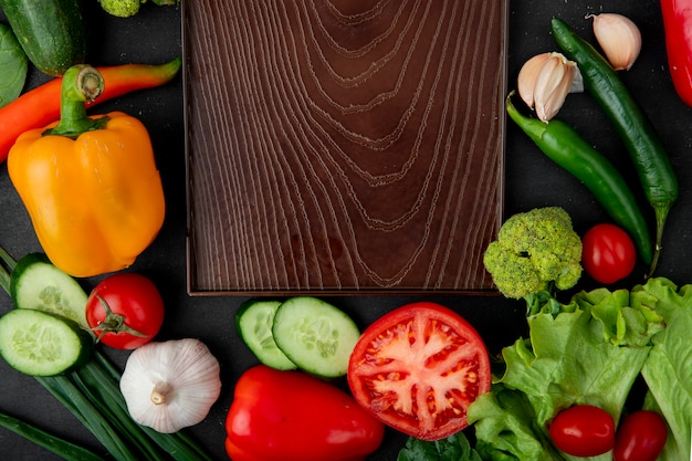 verduras con tabla de cortar en mesa granate