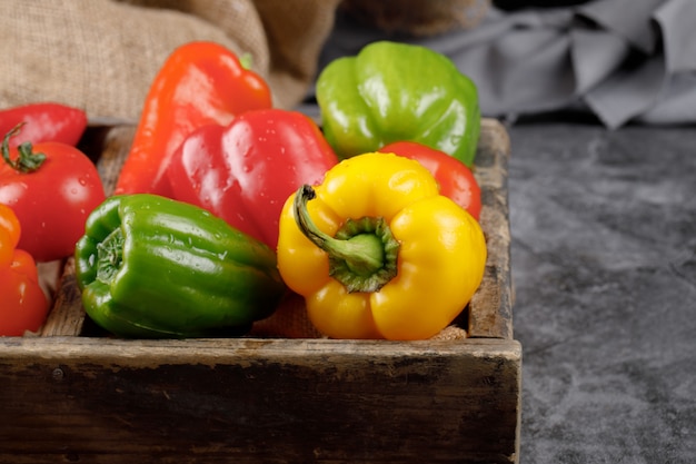 Verduras de temporada en una bandeja rústica sobre la piedra gris.