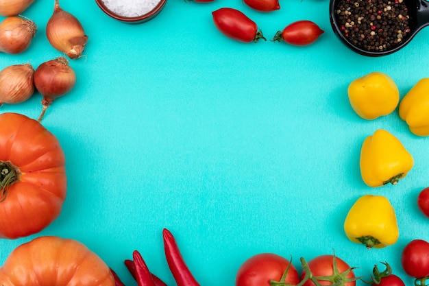 Verduras tomates cebolla pimiento vista superior sobre superficie azul