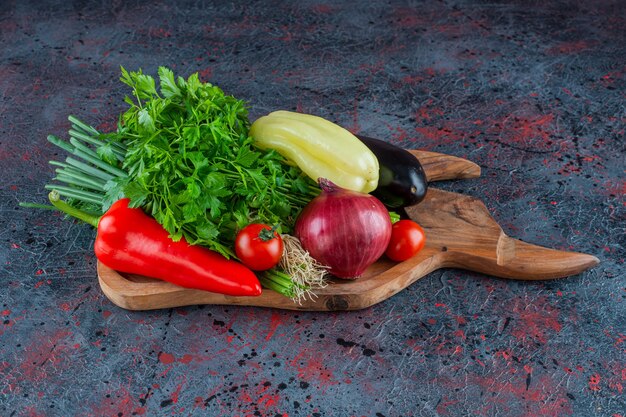 Verduras y verduras en una tabla de cortar, sobre el fondo de mármol.