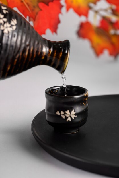 Verter la bebida de sake en la taza de bodegón
