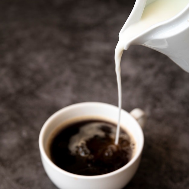 Verter la leche en una taza de café