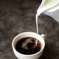 Foto gratuita verter la leche en una taza de café