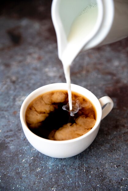 Verter la leche en una taza de café