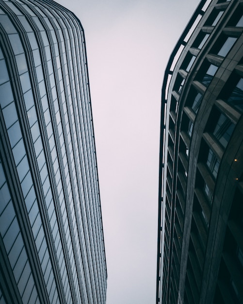 Vertical hacia arriba de modernos edificios comerciales altos con un cielo blanco