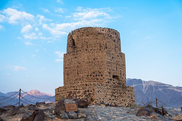 Vertical de la histórica torre Al Rabi contra el azul cielo nublado en los Emiratos Árabes Unidos.