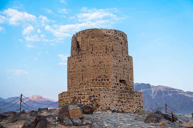 Vertical de la histórica torre Al Rabi contra el azul cielo nublado en los Emiratos Árabes Unidos.