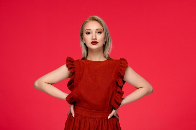 Vestido rojo elegante linda mujer rubia con vestido burdeos con lápiz labial con las manos en la cintura