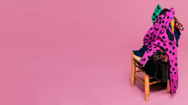 Vestidos de flamenca en silla con fondo rosa