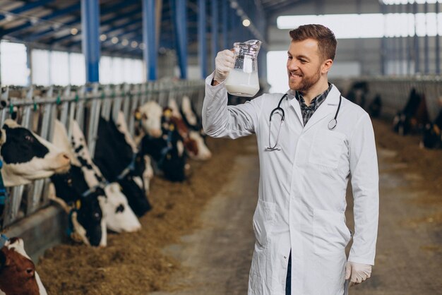 Veterinario en establo con jarra de leche