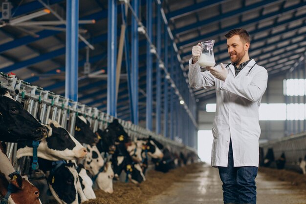 Veterinario en establo con jarra de leche