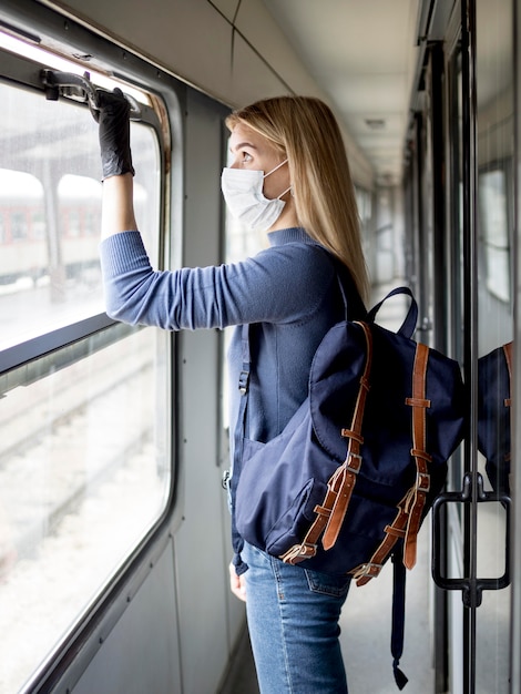 Viajando mujer en tren con máscara