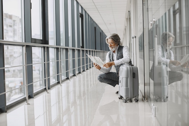 Viaje de negocios. Concepto corporativo y personas. Hombre con un abrigo gris. Senior con un mapa.