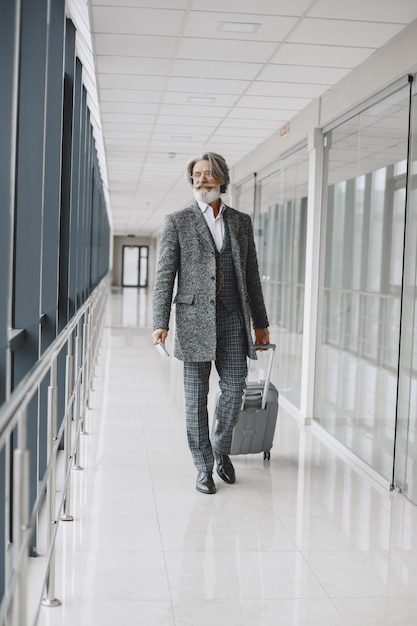 Viaje de negocios. Concepto corporativo y personas. Hombre con un abrigo gris. Senior con pasaporte.
