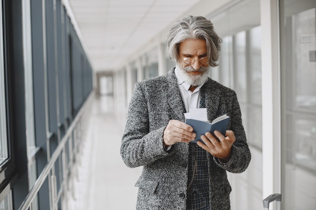 Viaje de negocios. Concepto corporativo y personas. Hombre con un abrigo gris. Senior con pasaporte.