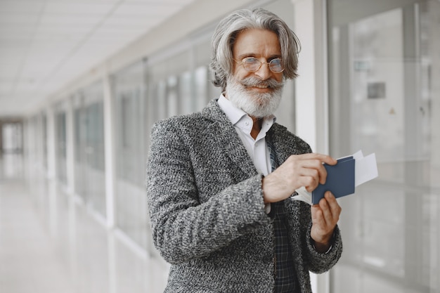 Viaje de negocios. Concepto corporativo y personas. Hombre con un abrigo gris. Senior con pasaporte.