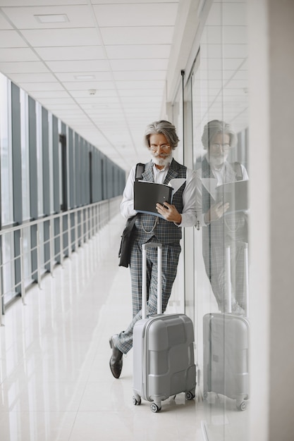 Foto gratuita viaje de negocios. concepto corporativo y personas. hombre con traje gris. senior con documentos.