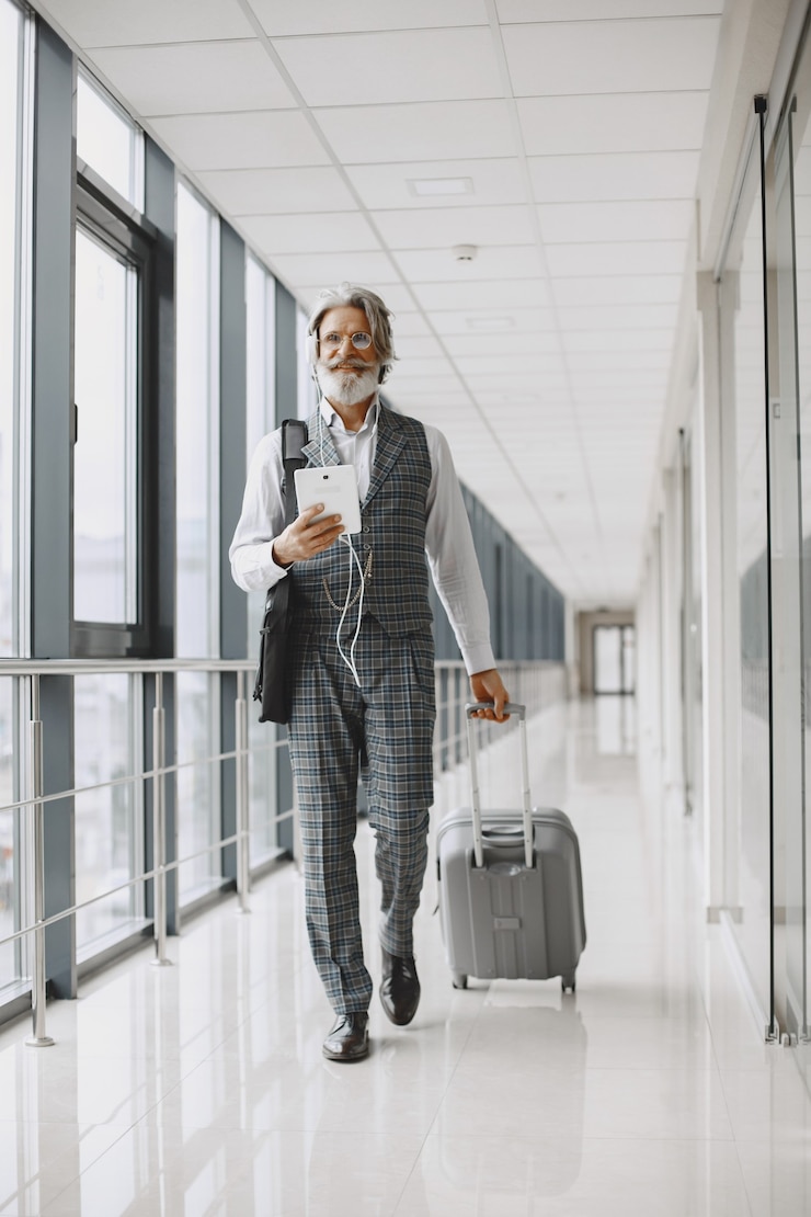 Foto gratuito viaje de negocios. concepto corporativo y personas. hombre con traje gris. senior con tableta y auriculares.