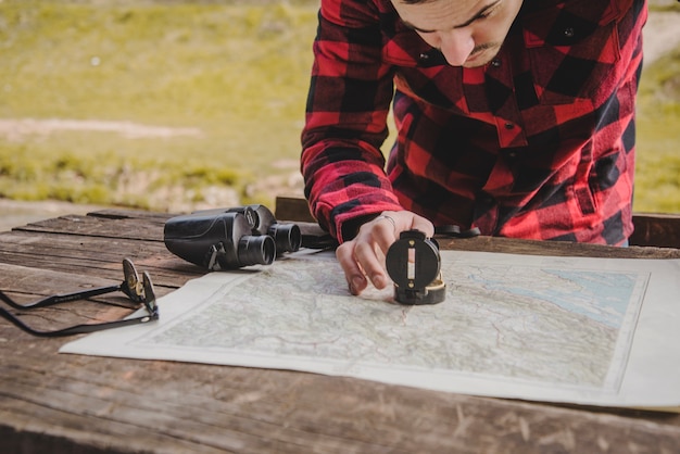 Viajero buscando el camino en el mapa con una brújula