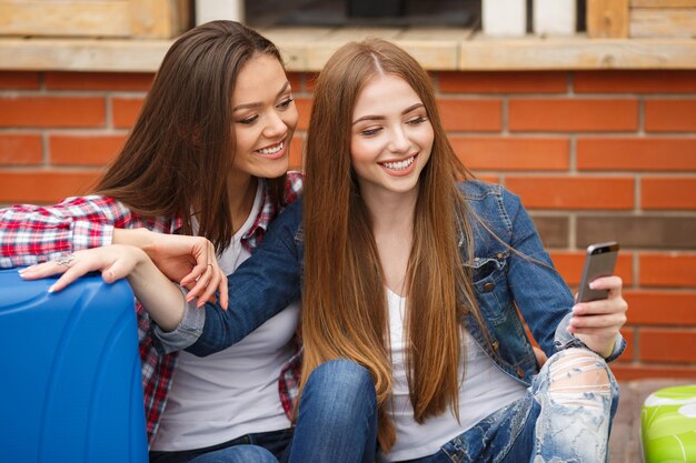 Viajero de dos jóvenes amigos con maleta