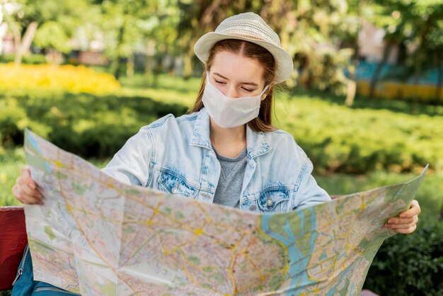 Viajero con máscara médica mirando el mapa