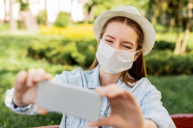 Viajero con máscara médica tomando una foto del uno mismo