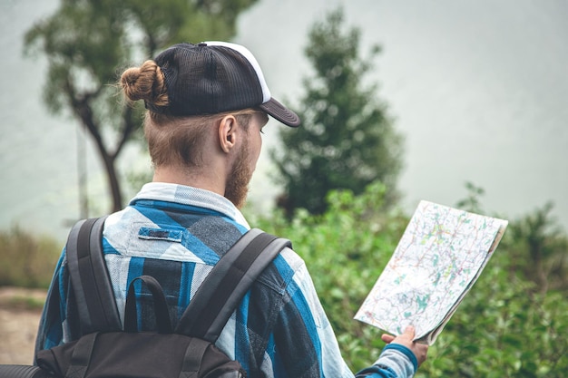 Viajero masculino mirando el mapa concepto de senderismo