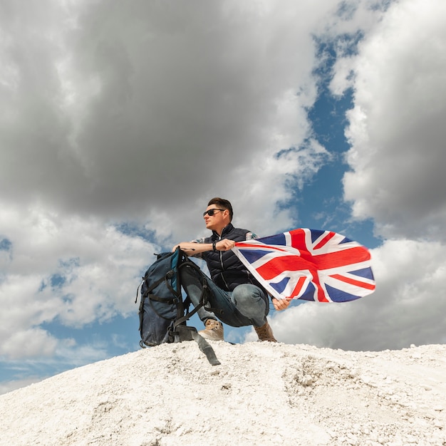 Viajero masculino con mochila y bandera