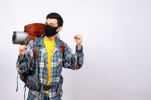 Viajero masculino de vista frontal con mochila y máscara expresando sus sentimientos