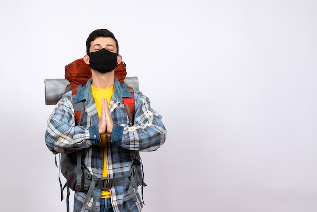 Foto gratuita viajero masculino de vista frontal con mochila y máscara uniendo sus manos