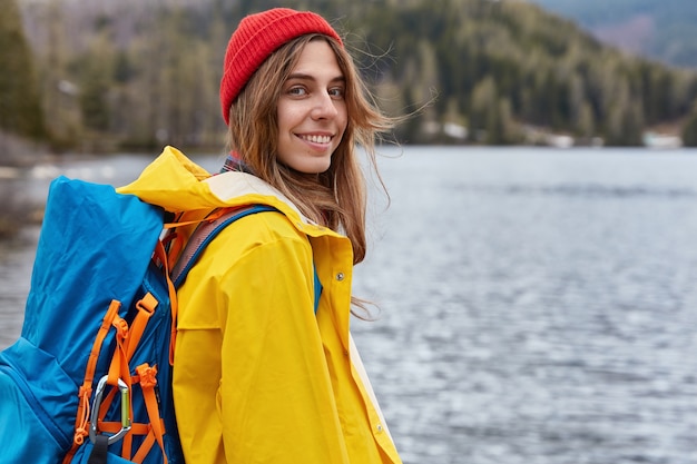 Viajero mujer caucásica muy sonriente lleva mochila