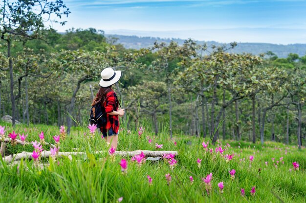 Viajero de mujer con mochila disfrutando en el campo de flores de Krachiew, Tailandia. Concepto de viaje.