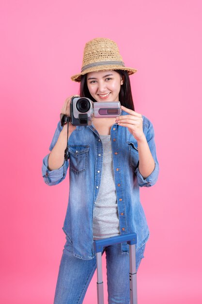 Viajero mujer con sombrero de traw sostiene grabadora de video, Retrato de adolescente feliz muy sonriente en rosa