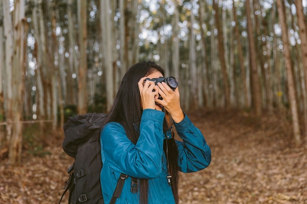 Foto gratuita viajero mujer tomando foto en el bosque