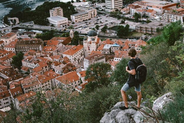 Viajero parado en una montaña y mirando por la noche el casco antiguo de Kotor Montenegro