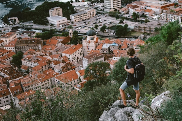 Viajero parado en una montaña y mirando por la noche el casco antiguo de Kotor Montenegro