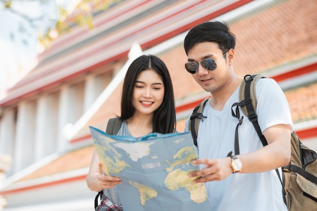 Foto gratuita viajero pareja asiática dirección en mapa de ubicación en bangkok, tailandia