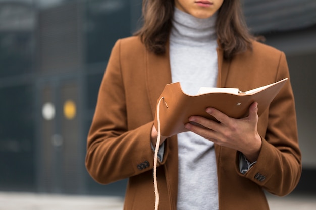 Viajero de primer plano leyendo un libro