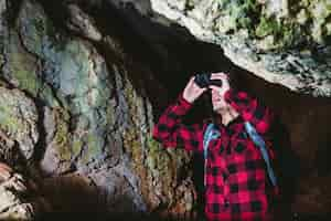 Foto gratuita viajero con prismáticos en la cueva