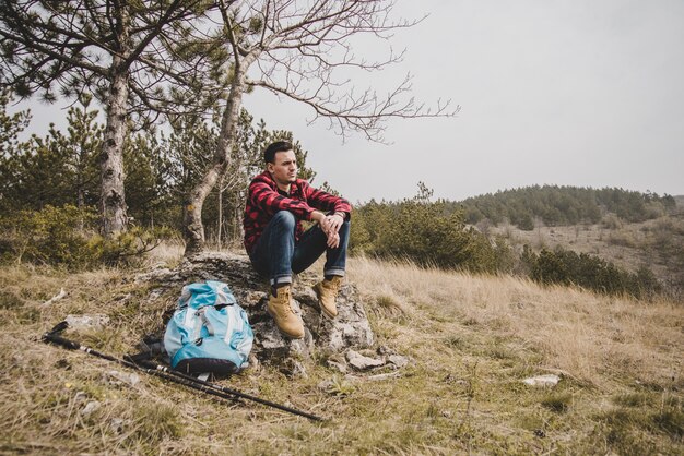 Viajero relajado descansando en una roca