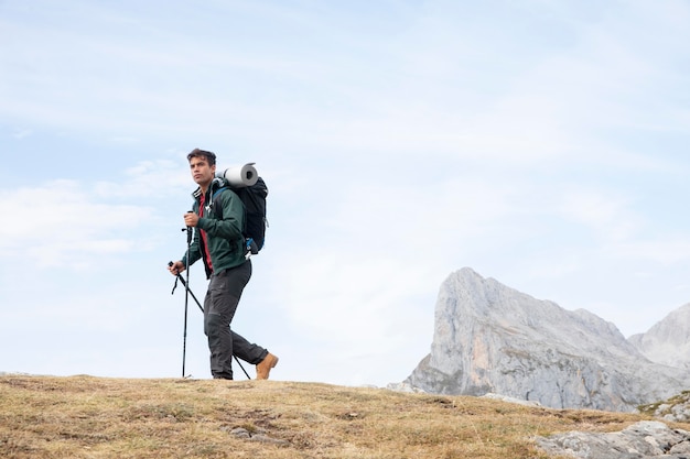 Viajero de senderismo en las montañas mientras tiene sus elementos esenciales en una mochila