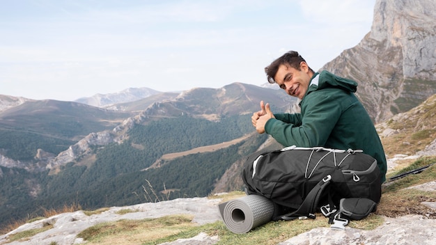 Viajero de senderismo en las montañas mientras tiene sus elementos esenciales en una mochila