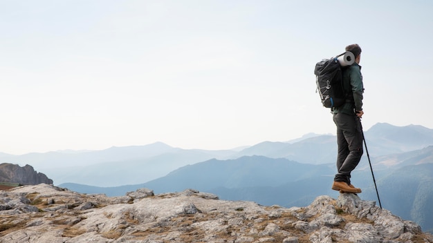 Viajero de senderismo en las montañas mientras tiene sus elementos esenciales en una mochila