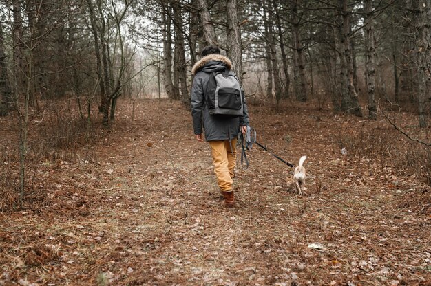 Viajero de tiro completo en el bosque con lindo perro