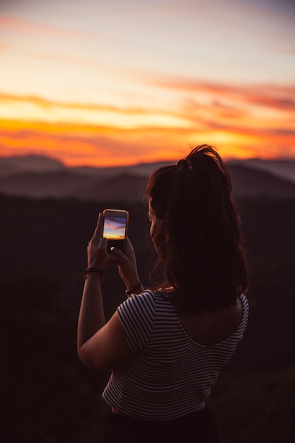 Viajero tomando una fotografía de la puesta del sol