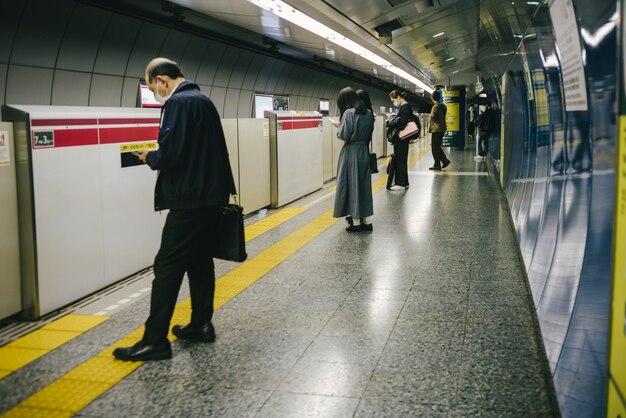 Viajeros esperando el tren subterráneo en la estación.